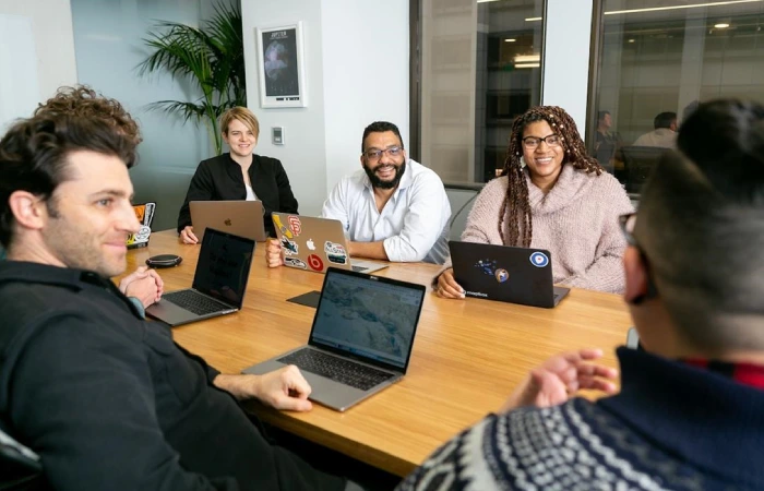 A team sitting at a table discussing how positive client references can help their business.